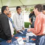 a student and their parents at a booth during an event