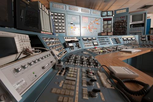 Panels of switches, knobs and dials set in grey metal.