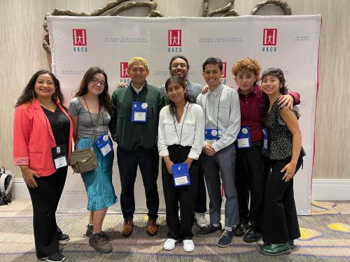 Emmanuel Fonseca smiling along with a group at the Hispanic Association of Colleges and Universities event.