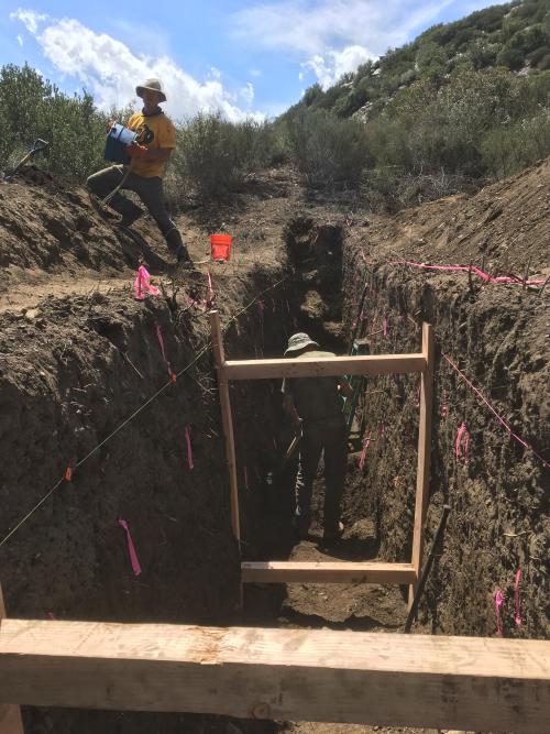 Two people working in a trench