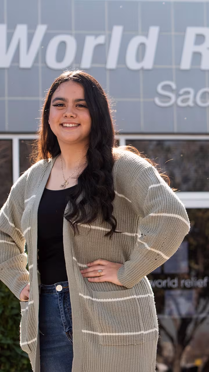 Female student stands in front of World Relief offices