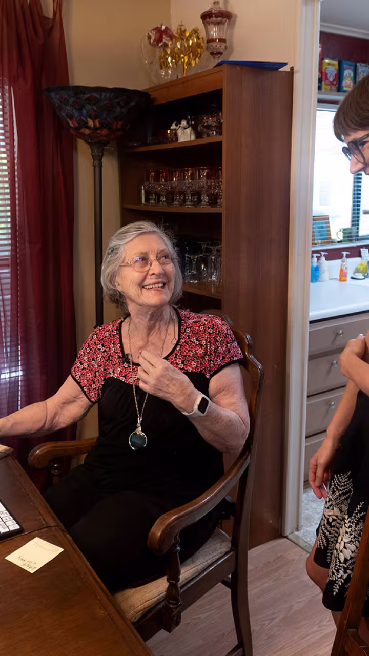Researcher talks with older patient in her dining room