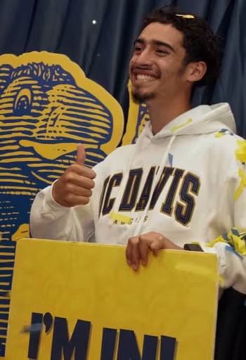 New UC Davis student Gabriel Hernandez from Modesto, California, poses with a cutout of Gunrock during Aggie Day 2023.