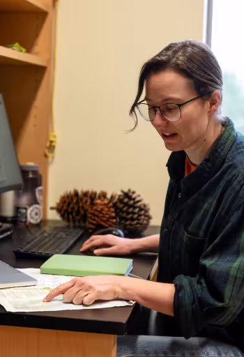 Nina Venuti sits at a desk in her lab