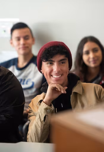 Students smile and listen in a lecture.