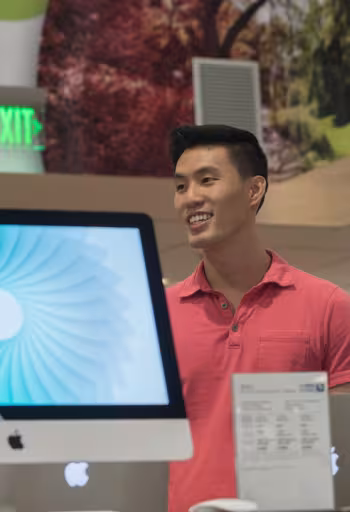A UC Davis stores student staff member discusses computer options in the computer section of the flagship UC Davis store.