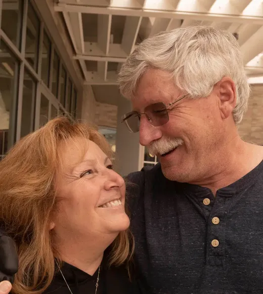 A smiling couple gazing into each other’s eyes, enjoying a joyful moment together.