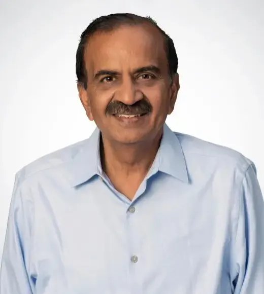 Smiling middle-aged man with mustache wearing light blue shirt, neutral background