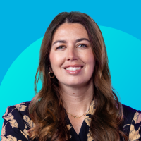 Headshot of smiling woman with long brown hair on teal-blue background