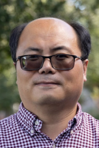 Man with glasses and dark hair in a red shirt