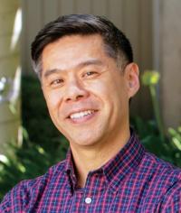 dark-complected man with purple shirt, dark hair