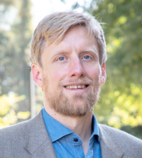 Man with light hair and beard outdoors at law school