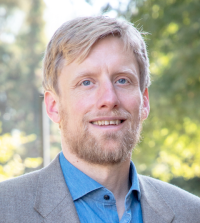 Man with light hair and beard outdoors at law school 