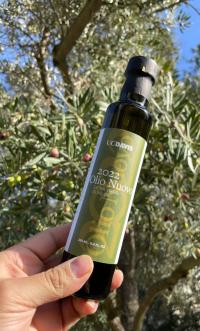 "Olio Nuovo" olive oil bottle, slender, green, in hand