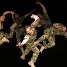 Five dancers dressed in army camouflage caught in various positions suepended in the air.