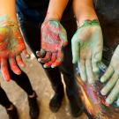 Art studio majors show their hands after painting with acrylics.