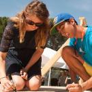 Female and male student signing a board