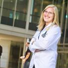 Biolology alumna Kate Brown Richards posing in her doctor's coat at UC Davis Medical Center