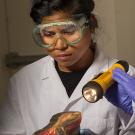 Forensic studies graduate student Arbie Manuel inspects a shoe sole 