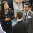 Four students in office clothes chatting in a circle