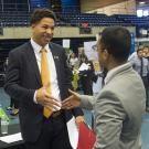 Job applicant shakes hands with a company representative at a UC Davis career fair