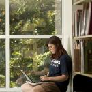 A woman looks at her laptop in the library