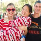 Three women in pajamas with one in the arms of another