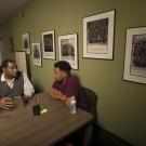 Two men talk at a table