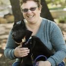 Elisabeth Paige holds her service dog, Pago