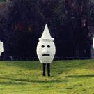 photo: three people inside giant human heads