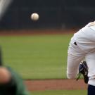 Baseball player pitching to hitter in foreground