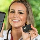 A woman holds up a device