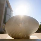 "Bookhead": Egghead sculpture, nose in book, sun behind