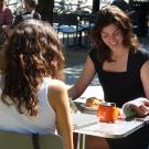 Two women read while seated at table