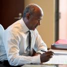 Chancellor Gary S. May writes at a desk.