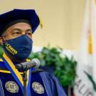 Chancellor Gary S. May in commencement regalia and wearing a UC Davis-branded face mask.