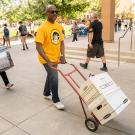 Chancellor Gary S. May moves boxes for a student.