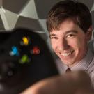 Colin Milburn holds a video game console