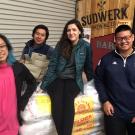 Iron Brew 2017 winning team poses around sacks of malt at Sudwerk Brewing Co.