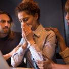 Two work colleagues comfort a crying woman 