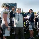 Dan Hawkins speaks to players at a football practice.