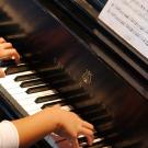 Arms of a young woman playing the piano