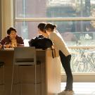 A group of students study together in a sunny atrium.