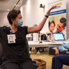 Woman lifts arms in celebration after receiving vaccine.