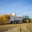 Wood chips from recycled almond trees spread across orchard by truck