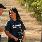 Man and woman in orchard being videotaped