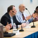 Speakers seated at a table.