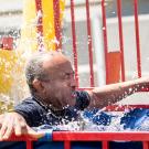 Chancellor Gary S. May falls into a dunk tank.