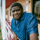 Gary Younge on balcony, environmental portrait