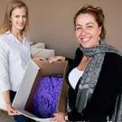 Women hold box of used lab gloves.